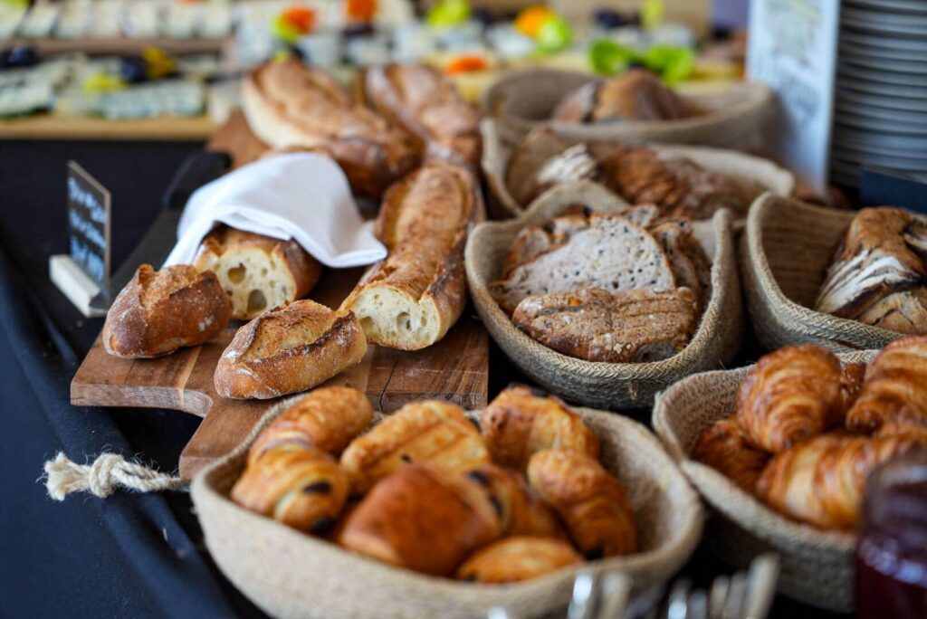 Baguettes, pains tranchés, croissants et pains au chocolat sur un buffet