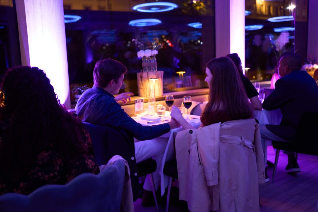 Couple se tenant la main lors d'un dîner à bord d'un bateau